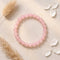 A pink rose quartz beaded bracelet specifically used for heart chakra balancing and emotional healing.