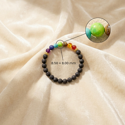 Close-up view of the 7 Chakra bracelet beads showing dimensions of 8.50 \times 8.00 mm on a soft velvet background.