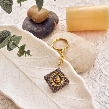The Natural Pyrite OM Keychain presented in its packaging, making it a perfect spiritual gift for luck.