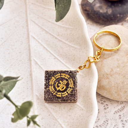 A natural pyrite OM talisman keychain used as a manifestation tool for success and prosperity.