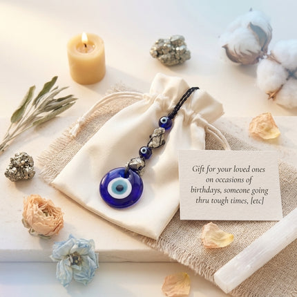 Raw Pyrite Evil Eye keychain presented on a white drawstring pouch with a gifting note, perfect for protecting loved ones and inviting prosperity