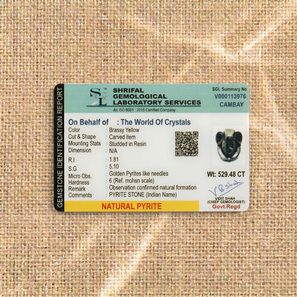 Gemstone identification report from Shrifal Gemological Laboratory for a Natural Pyrite Ganesha statue by The World Of Crystals, confirming a carved pyrite item studded in resin with a weight of 529.48 CT