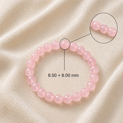 Technical view of the Natural Rose Quartz bracelet showing genuine 8.50x8.00 mm pink crystal beads on a soft fabric background