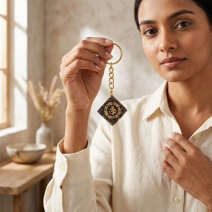 A stylish gold-toned pyrite OM keychain attached to a set of keys, showcasing its use as a spiritual everyday accessory.