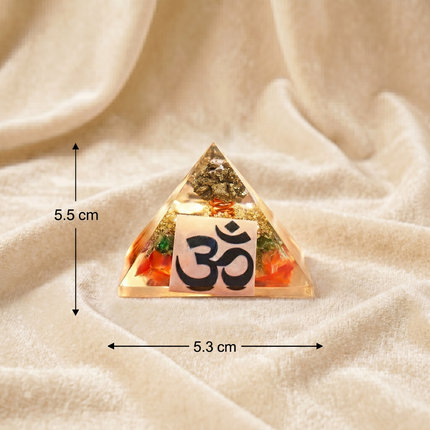 Measurement guide for the Shree Yantra Orgone Pyramid showing a height of 5.5 cm and a base width of 5.3 cm on a soft textured fabric background.