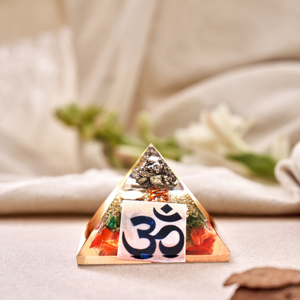Pyrite orgone pyramid with OM symbol used as a spiritual tool for financial success, abundance, and energy balancing