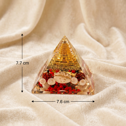 Measurement guide for the Shree Yantra Orgone Pyramid showing a height of 7.7 cm and a base width of 7.6 cm on a soft textured fabric background