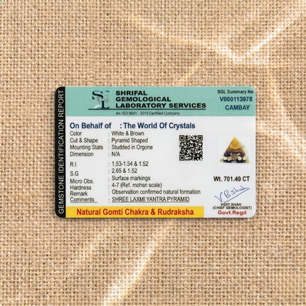 Gemstone identification report from Shrifal Gemological Laboratory for a Natural Gomti Chakra and Rudraksha Shree Laxmi Yantra Pyramid by The World Of Crystals, confirming natural formation and 701.49 CT weight